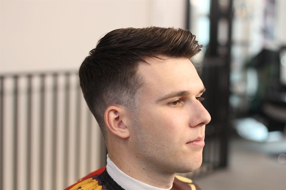 Side profile of a clean taper fade with textured top