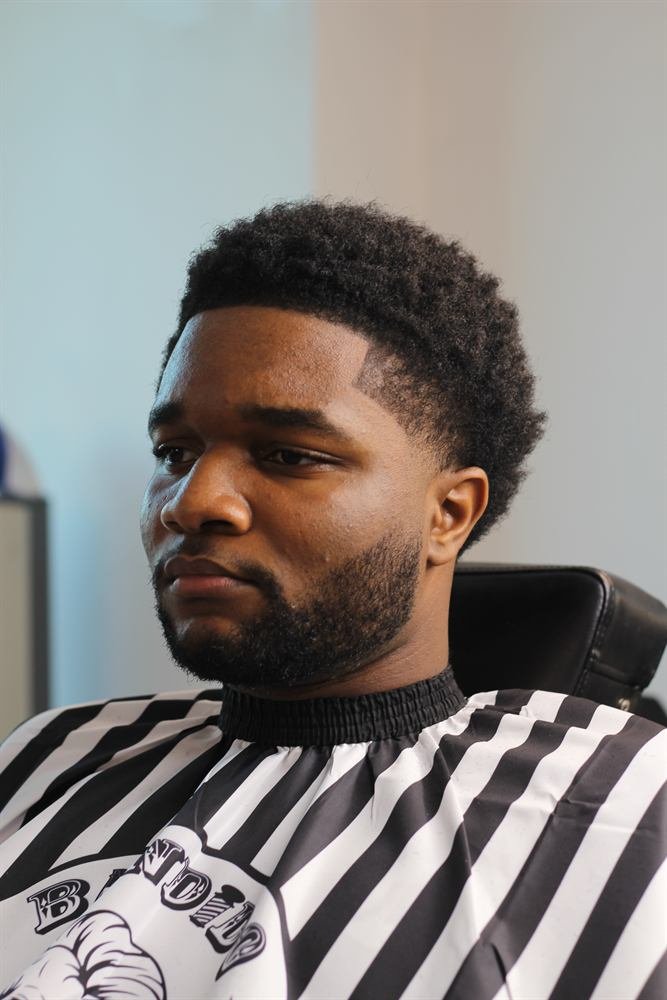 Client with a sharp beard line-up and textured curls