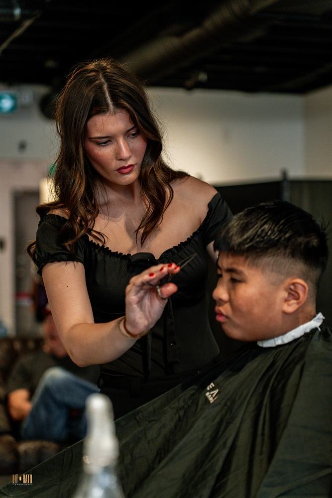 Barber-stylist styling a client's hair in the chair
