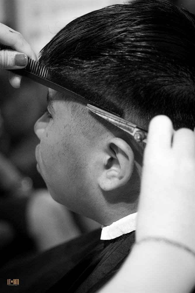 Close-up of a barber using a comb and clipper on a fade