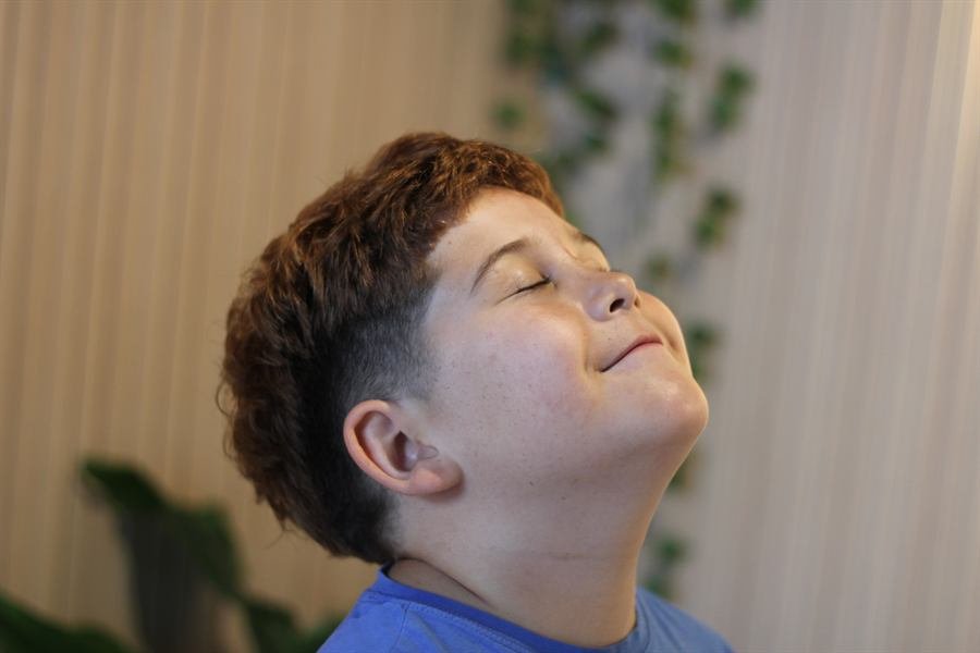 Smiling boy with a fresh curly-top cut