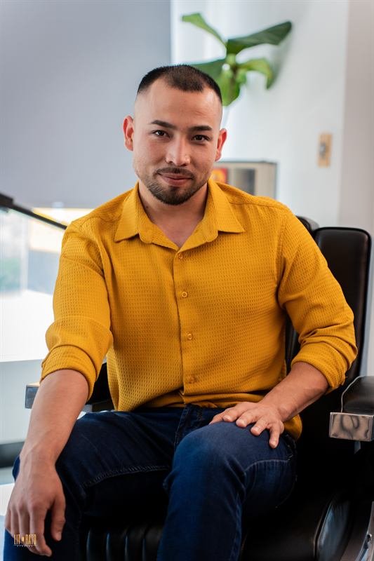 Reza, barber, seated in a barber chair
